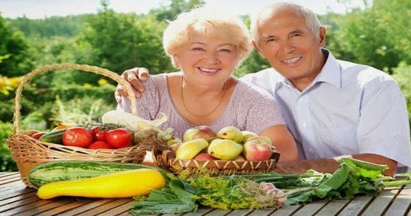 blog picture of elderly couple sitting outside with vegetables
