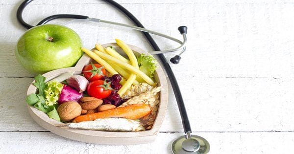 blog picture of vegetables inside a heart with an apple and stethoscope lying next to the heart