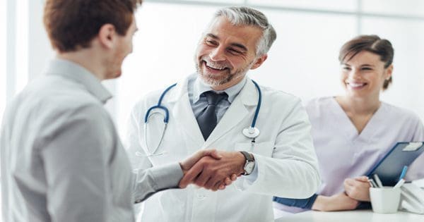 blog picture of doctor shaking patients hand with nurse or assistant in background