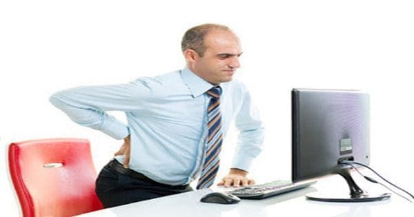 na blogu zdjęcie mężczyzny przy biurku z bólem rwy kulszowej