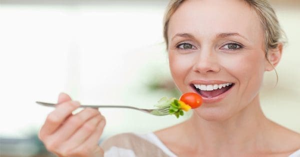 blog picture of lady eating tomato and other vegetables