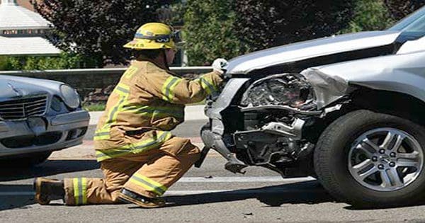blog picture of firefighter at auto accident looking at front of car