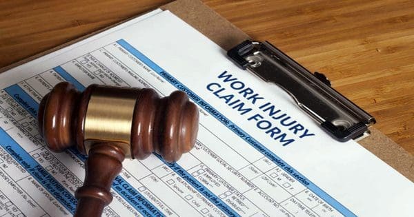 blog picture of work claim injury form on clipboard and a gavel laying on top