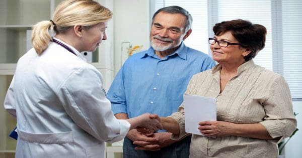 blog picture of doctor talking with an older couple about chiropractic