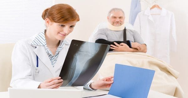 blog picture of doctor looking at x ray of patient sitting in the background
