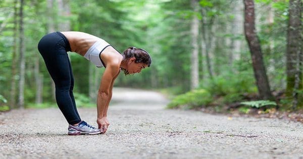 blog picture of lady stretching on running trail