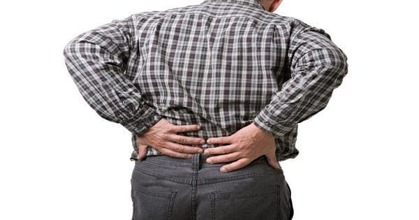 blog picture of a man standing holding his lower back in pain