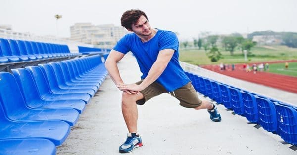blog picture of runner stretching leg out in stadium seats