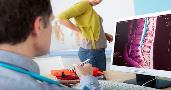 blog picture of a man sitting down in an office and a lady showing signs of sciatica