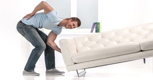 blog picture of man lifting couch and grabbing his back in pain