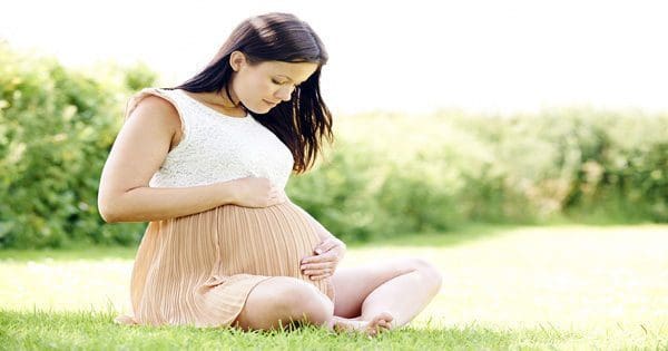 blog picture of pregnant lady sitting on the grass