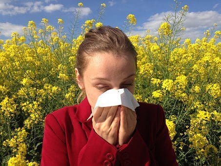 blog picture of lady in flower field with allergies
