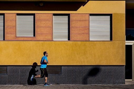blog picture of man jogging by a building