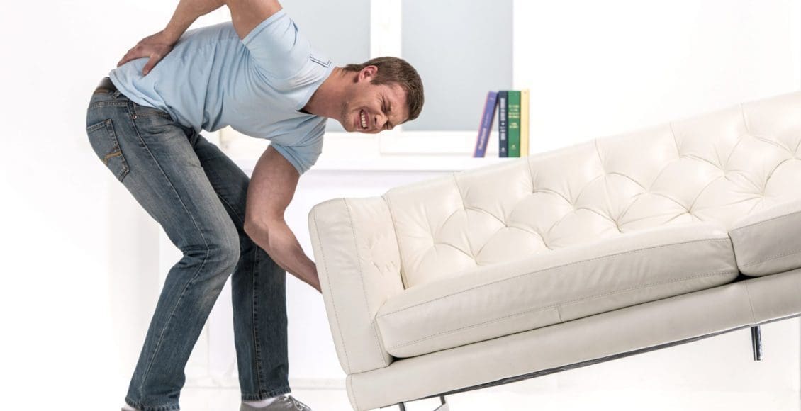 man trying to lift couch wrong way ends up with back pain