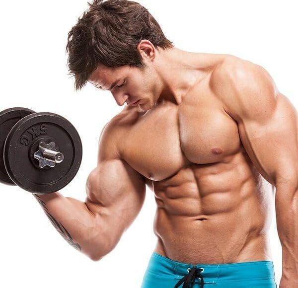 young man doing arm curls no shirt all muscles