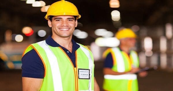 Construction Worker Smiling with background of other workers